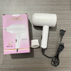 White hair dryer with packaging and plug on a wooden surface