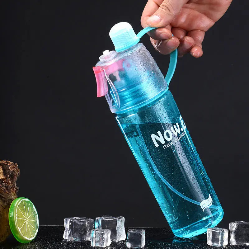 Hand holding a spray bottle with mist nozzle and transparent body for hydration