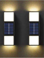 Two solar wall lights on a textured wall